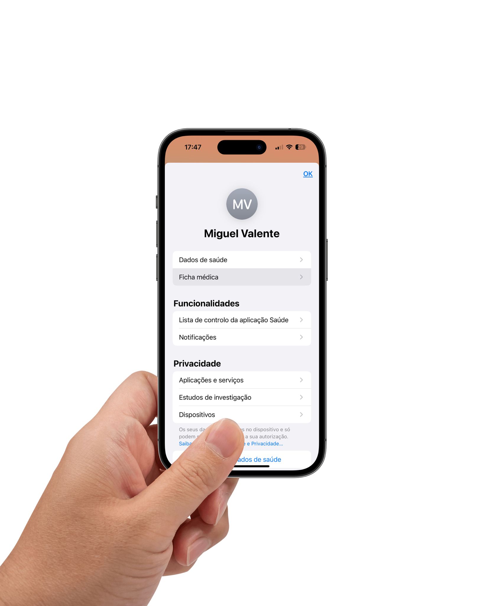 Mão esquerda a segurar um iPhone 14 que mostra o ecrã que surge depois de carregares no teu perfil na aplicação Saúde, com a opção "Ficha Médica" selecionada. 