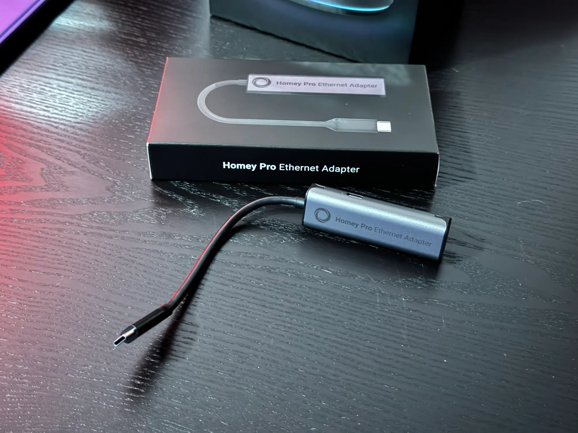 Um Adaptador Ethernet para o Homey Pro em cima de uma mesa.