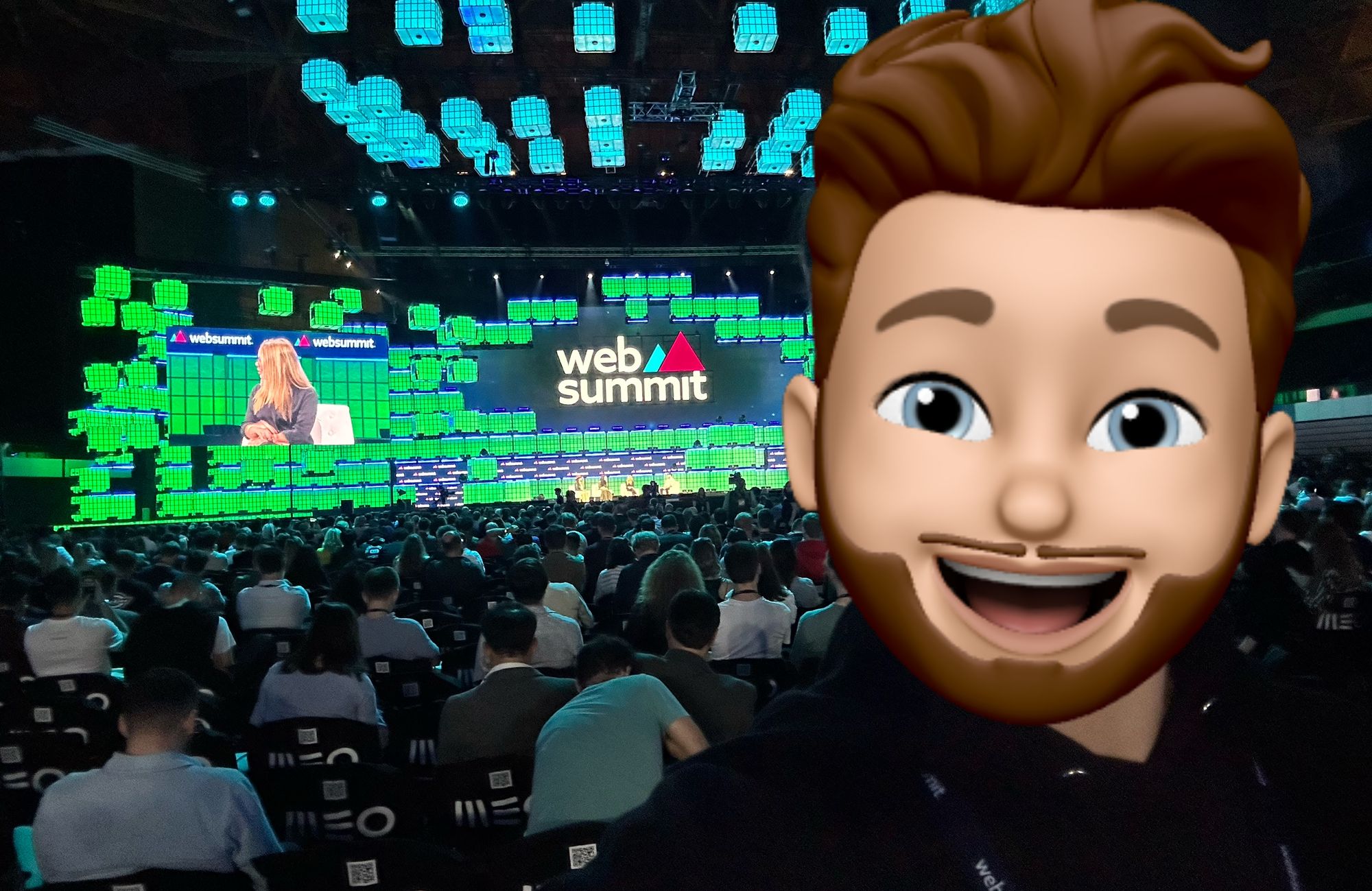 Selfie na plateia do palco principal da Web Summit 2023 com um memoji sorridente a tapar a cara da pessoa.